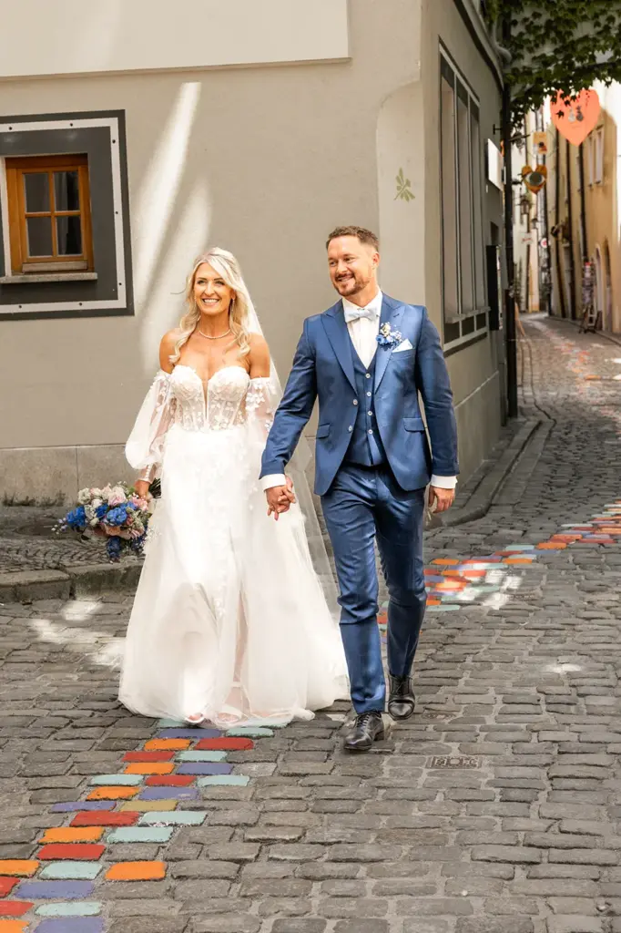Brautpaar spaziert durch die Altstadtgassen von Passau Hand in Hand.