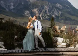 Brautpaar küsst sich auf Holzbohlen am Naturteich der Tiergartenalm